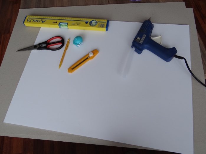 Everything I used: a piece of foamboard, two big pieces of cardboard, a pencil, scissors, box cutter, measuring tape, hot glue gun and something that helps you draw straight lines